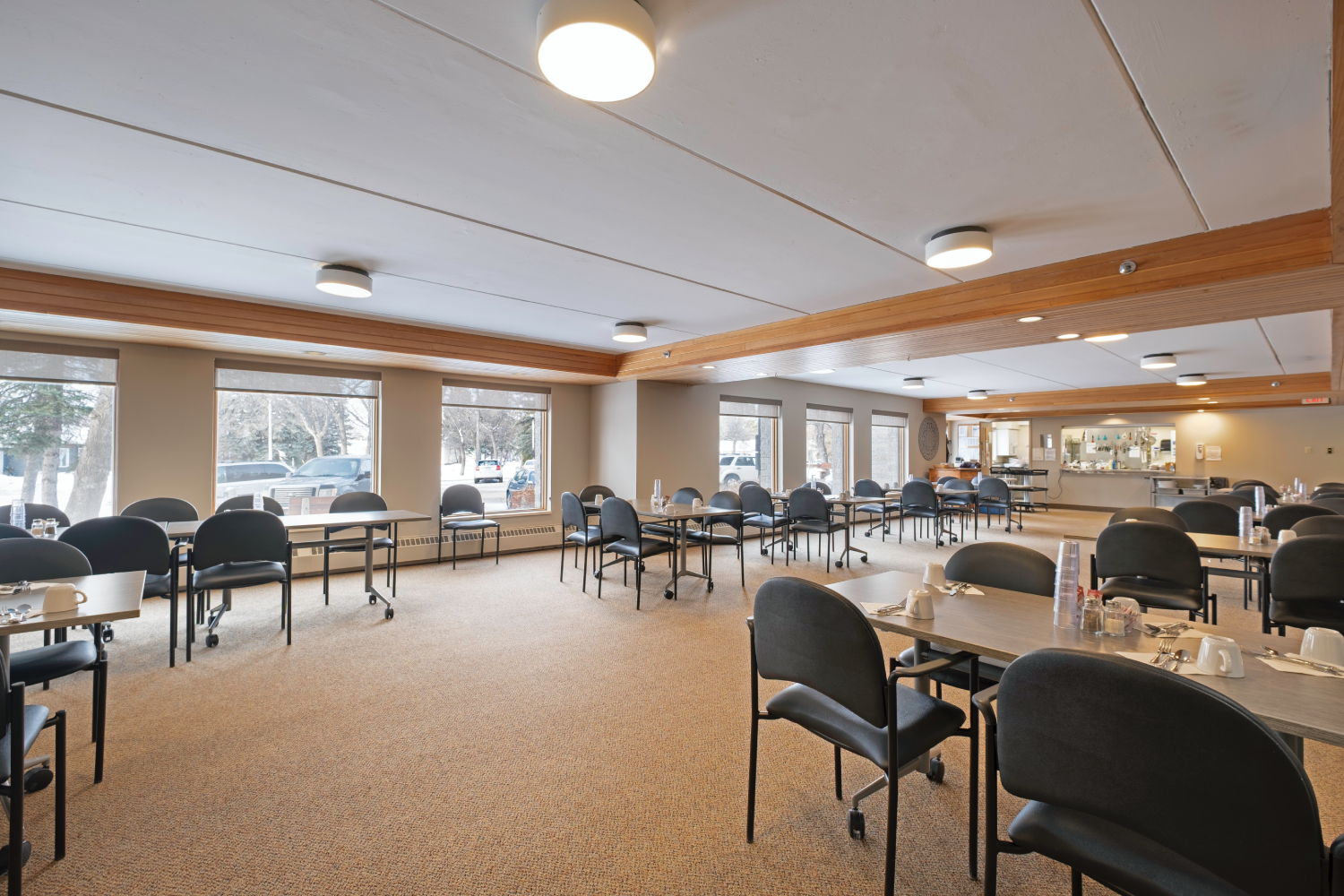 Large, light-colored room with rows of tables and chairs, suitable for a community or senior center dining area. Large, light-colored room with rows of tables and chairs, suitable for a community or senior center dining area.